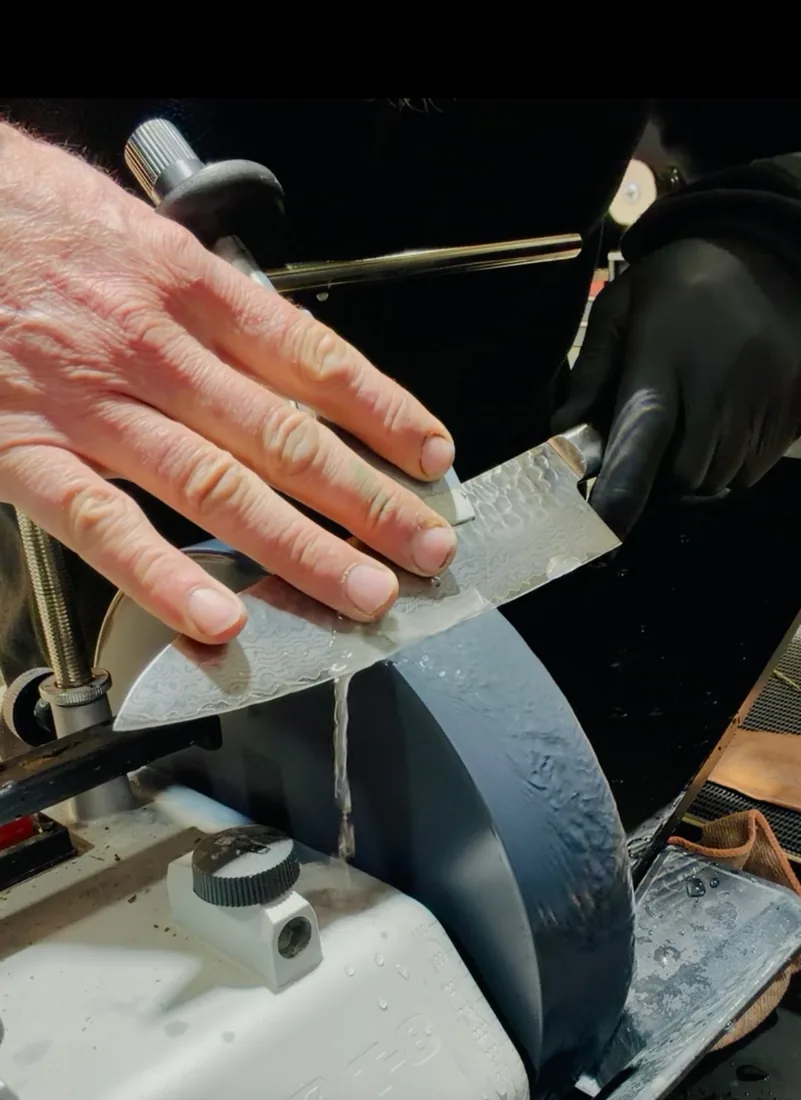 Matt sharpening a Damascus chef knife on his water-cooled wheel